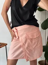 Minifalda cruzada color salmón, con lazo lateral y bolsillo tipo parche.
