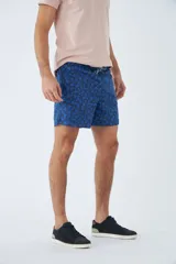Short de baño celeste con estampado de líneas curvas en azul. Cuenta con cintura elástica con cordón ajustable, dos bolsillos laterales, un bolsillo trasero, suspensor interno y logo bordado.