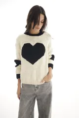 Sweater tejido a mano en Uruguay, color crudo con corazón negro en el frente y detalles en negro en cuello y puños.