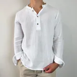 Camisa blanca de muselina con cuello mao y manga larga con puños abotonados.