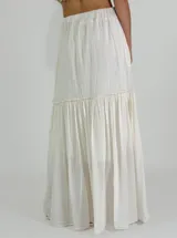 Pollera larga color crudo, de corte amplio y con volados.