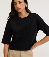 Remera cropped de algodón, color negro, con cuello redondo y mangas cortas.