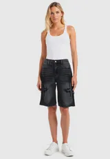Bermuda de jean negro con efecto lavado, corte holgado y largo a la rodilla. Presenta detalles de roturas con apliques de tela en los laterales.