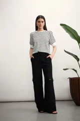 Pantalón cargo negro de corte amplio, con bolsillos laterales con solapa y ajuste con cordón en la cintura.