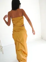 Top strapless color ocre con frunces y efecto origami.