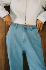 Pantalón de jean azul oscuro, corte carrot, tiro medio, largo cropped, con cintura elástica en la parte trasera, bolsillos delanteros y traseros, cierre con cremallera y botón.