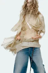 Vestido corto con estampado floral en tonos beige y rosa, escote pico y tirantes finos. Detalle de capa asimétrica con cuello subido y lazada. Forro interior combinado a contraste y bajo acabado con volantes.