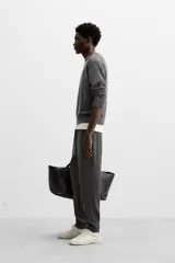Pantalón negro de corte cropped, con cintura elástica ajustable con cordón, bolsillos laterales y traseros de vivo. El bajo tiene terminación con vuelta.