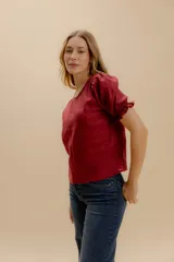 Blusa negra de lino con mangas abullonadas y puños elásticos.