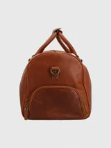 Bolso de viaje tipo maletín, fabricado en cuero natural color caramelo. Presenta dos asas superiores y una correa ajustable y desmontable. Cuenta con un compartimento principal con cierre, un bolsillo interior con cierre y un bolsillo lateral con cierre.