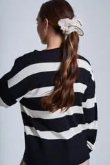 Sweater Bremer con cuello redondo y mangas largas ligeramente amplias. Diseño a rayas horizontales en color crudo y negro.