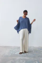 Poncho tejido de punto color azul con cuello en V y mangas amplias.