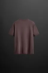 Camiseta color crudo de corte relaxed fit confeccionada en tejido técnico ligero de tacto suave, cuello redondo y manga corta. Tiene un texto estampado en el delantero y detalle de logo estampado en el bajo.