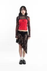 Top deportivo rojo con breteles finos y ribete negro, con logo ovalado en el pecho y dos líneas verticales negras en los laterales.
