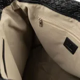 Bolso tote negro con textura símil cuero croco, doble asa corta y correa larga regulable y extraíble. Tiene cierre superior, dos bolsillos internos abiertos y uno con cierre.