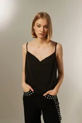 Musculosa blanca de poliéster con breteles finos, cuello drapeado y corte holgado.