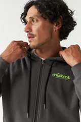 Campera de felpa color beige con capucha y cordón ajustable, cierre frontal, bolsillos con cierre, lettering estampado en la espalda y logo en grifa de goma.