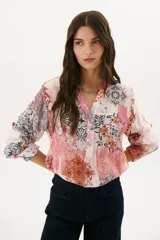 Camisa de manga larga con estampado abstracto en tonos rosa, blanco y negro.