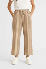 Pantalón capri de lino a rayas verticales en tonos beige y marrón, con cintura elástica ajustable con cordón.