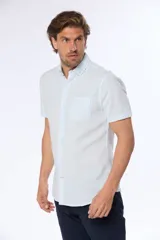 Camisa celeste y blanca a rayas verticales, de lino y algodón, manga corta, corte slim fit, con cuello abotonado y bolsillo en el pecho.