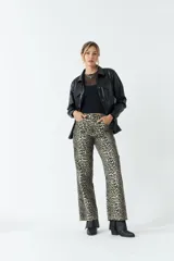 Sobrecamisa color beige de efecto cuero, con cuello clásico, cierre frontal con botones a tono, mangas largas con puños abotonados, dos bolsillos con solapa en el pecho y corte recto.