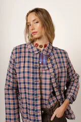 Campera con estampado a cuadros en tonos azul, rojo y amarillo, con cuello camisero, cierre frontal con botones y mangas largas.