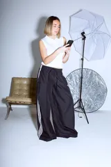 Pantalón Adidas Parachute negro de corte holgado con las tres rayas blancas a los costados.