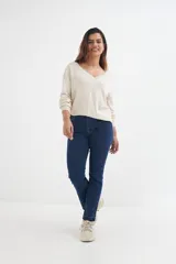 Sweater lila de tejido de punto, con escote en V y mangas largas.