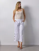Pantalón blanco de algodón con pretina elastizada, bolsillos inclinados y ruedo con botones.