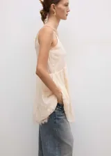 Vestido corto color crema con tirantes finos y escote en V, con detalles de encaje en escote y ruedo.
