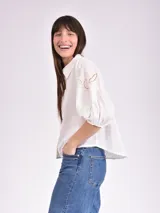 Camisa blanca de mangas 3/4 con detalles de calado en las mangas.