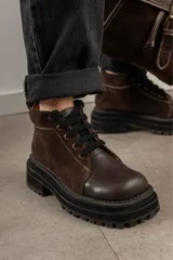 Borcegos negros de cuero charol, con punta cuadrada, cordones y suela track.