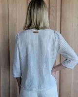 Camisa color beige claro con cuello con volados y mangas 3/4 abullonadas.