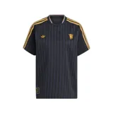 Camiseta de fútbol Adidas del Manchester United, modelo Terrace Icons. Diseño negro con finas rayas verticales en lila, detalles en dorado en cuello, mangas y logo de Adidas. Incluye escudo del club en el pecho.