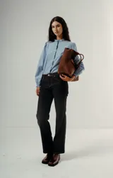 Pantalón de denim color negro lavado, de tiro medio y corte wide leg (pierna ancha y recta con caída fluida).