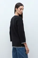 Saco de punto color ciruela oscuro, de manga larga y cuello redondo, con cierre frontal de botones y ribetes en contraste blanco con puntada decorativa.