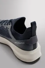 Zapatilla deportiva azul marino con capellada de tejido de punto transpirable, ajuste con cordones, plantilla OrthoLite® extraíble y suela con tecnología Spume Foam V2.
