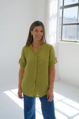 Camisa verde lima de lino con cuello mao, mangas cortas con dobladillo y cierre frontal con botones.