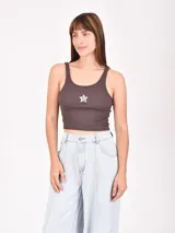 Musculosa corta marrón de morley con breteles finos y estampado de una estrella blanca en el centro.