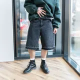 Bermuda de jean negro con corte holgado y terminaciones desflecadas.