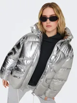 Campera puffer plateada con capucha, cierre frontal con cremallera y botones a presión, bolsillos delanteros con solapa y cordón ajustable en el dobladillo.