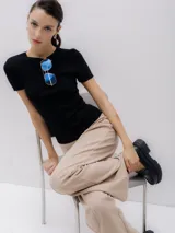 Top de punto negro con cuello redondo y manga corta.
