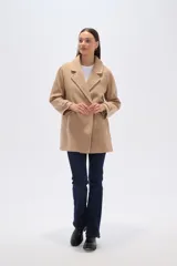 Tapado de poliéster color gris con cuello de solapa y cierre frontal de botones. Cuenta con mangas largas y un diseño de corte recto.