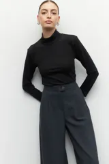 Top tipo polera negro de manga larga ceñido al cuerpo con un leve brillo.