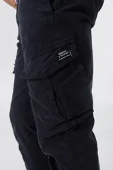Pantalón cargo color azul marino con bolsillos laterales con solapa y etiqueta con el logo de la marca.