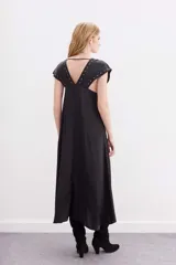 Vestido largo negro de viscosa jacquard con mangas cortas con detalle de tablas y ojalillos metálicos en mangas y escote.