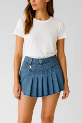 Minifalda short de jean azul con cintura alta, cierre con botón y cremallera lateral, y diseño plisado.