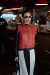 Bolso tipo tote bag con rayas horizontales verdes y blancas, asas de mano grises y aplique de cuero negro con logo en el centro.