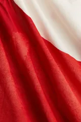 Top blanco con estampado de círculos rojos, escote redondo, breteles finos y corte evasé.