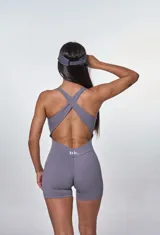 Catsuit deportivo gris con escote halter y cordones ajustables en el pecho.